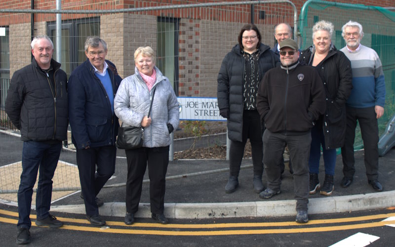 Friends and family of Joe Martin in front of the street name sign